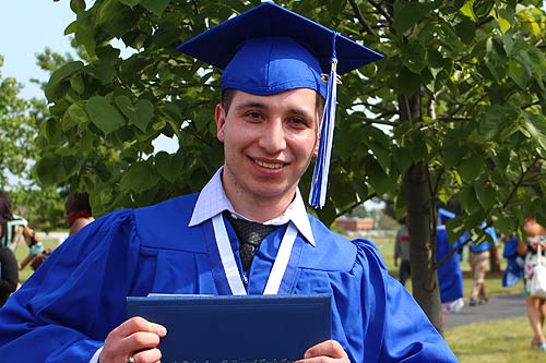 Photo of a graduate holding his diploma