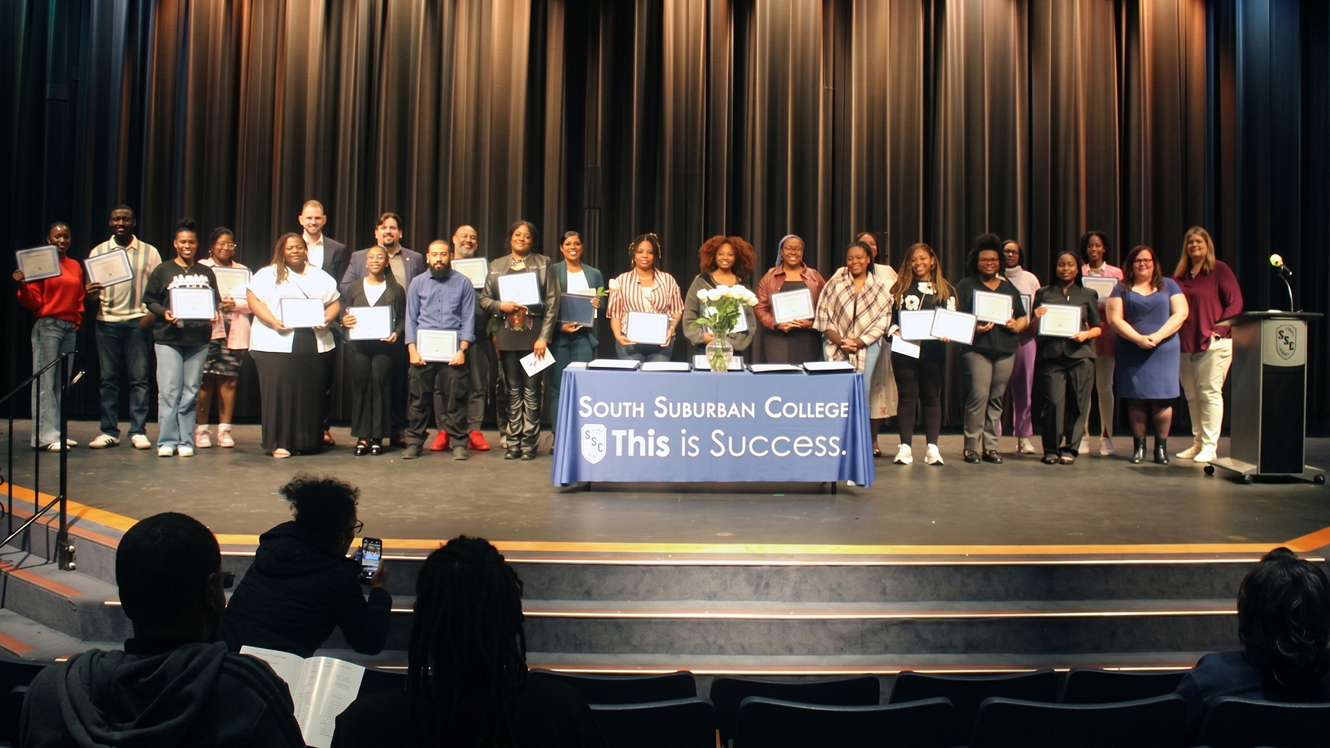 Phi Theta Kappa inductees, South Suburban College scholarship recipients, donors, and Foundation Board members pose for a group photo on stage at an Academic Achievement Reception.